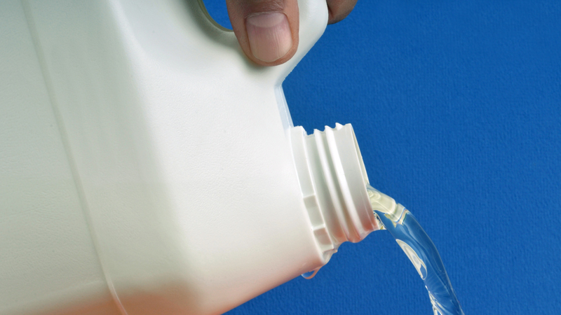 garrafão de lixívia a despejar líquido